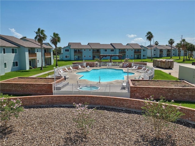 community pool with a yard, a patio, fence, and a residential view