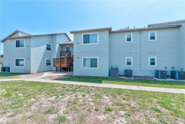 back of property featuring a lawn and cooling unit
