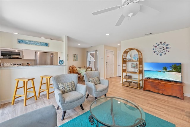 living area with recessed lighting, baseboards, visible vents, and light wood-style flooring