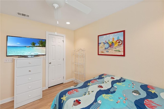 bedroom featuring a ceiling fan, baseboards, visible vents, and light wood-style flooring