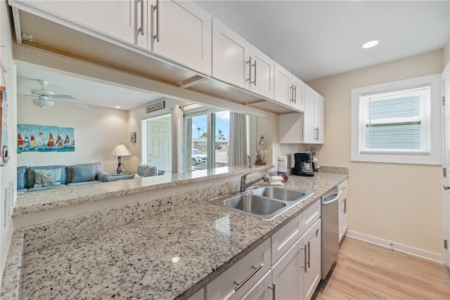 kitchen with baseboards, white cabinetry, a sink, light wood-style flooring, and dishwasher