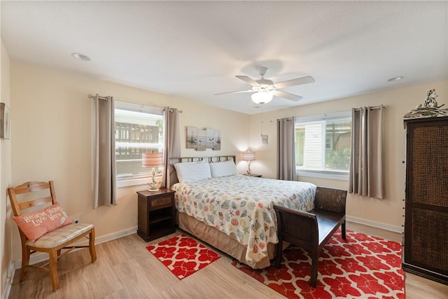 bedroom with baseboards, ceiling fan, and light wood finished floors