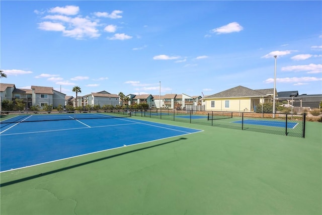 view of sport court with fence and a residential view