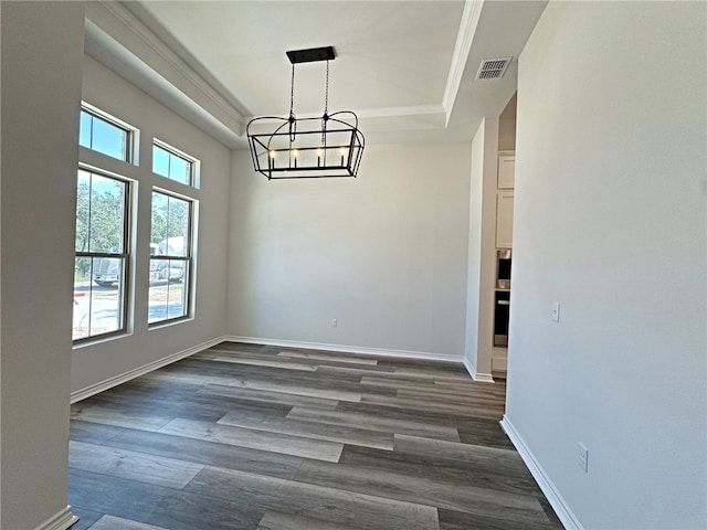 unfurnished dining area with a notable chandelier, dark hardwood / wood-style floors, and a raised ceiling