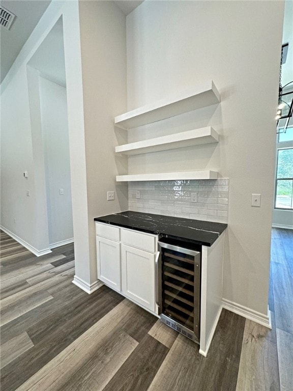 bar featuring white cabinets, decorative backsplash, dark hardwood / wood-style floors, and beverage cooler