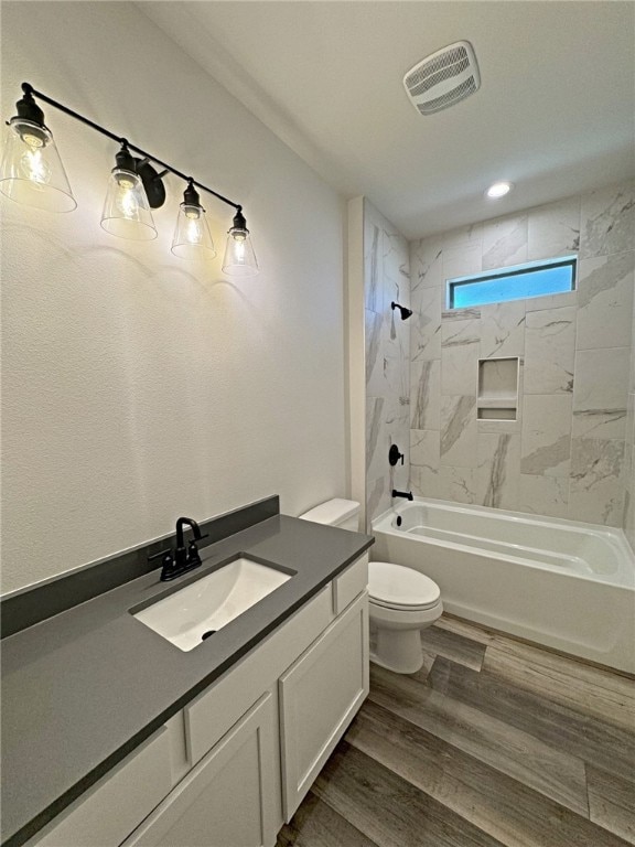 full bathroom with toilet, vanity, tiled shower / bath, and hardwood / wood-style flooring