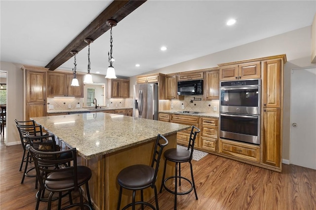 2641 Linn, Corpus Christi, TX 78410 - kitchen featuring stainless steel appliances, dark wood-type flooring, a kitchen island, a breakfast bar, and backsplash