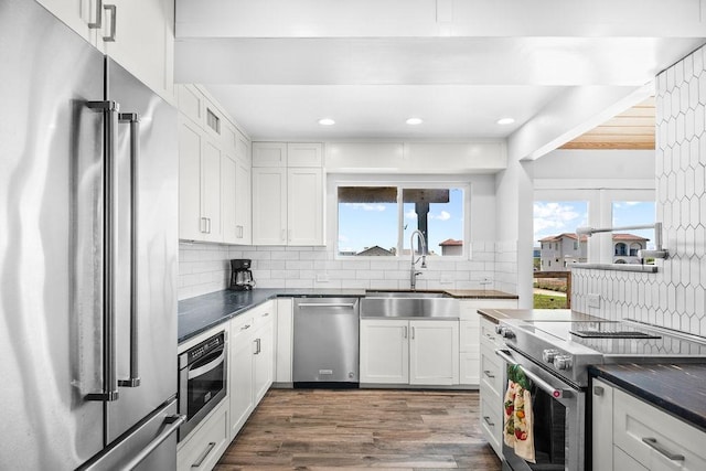 411 S 12th St, Port Aransas, TX 78373 - kitchen featuring stainless steel appliances, dark countertops, decorative backsplash, dark wood-style floors, and recessed lighting
