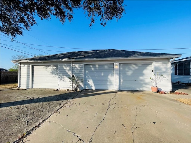 detached garage featuring fence