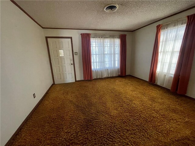 empty room featuring wooden walls, a ceiling fan, carpet floors, and a textured ceiling