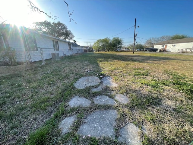 view of yard featuring central AC unit and fence