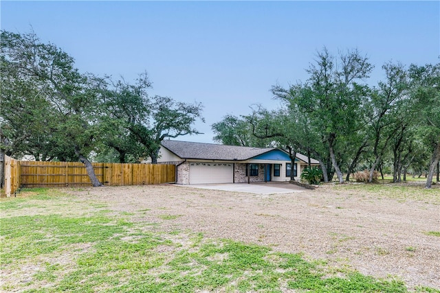 view of front facade with brick siding, fence, driveway, and a garage