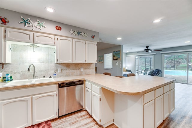kitchen featuring a sink, dishwasher, light wood-style flooring, a ceiling fan, and decorative backsplash