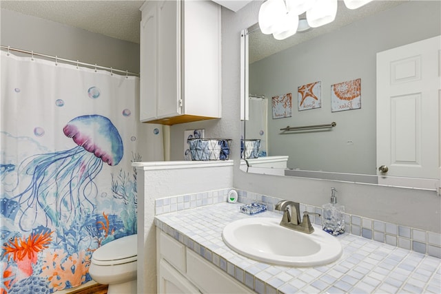 bathroom with vanity, toilet, a textured ceiling, and a shower with shower curtain