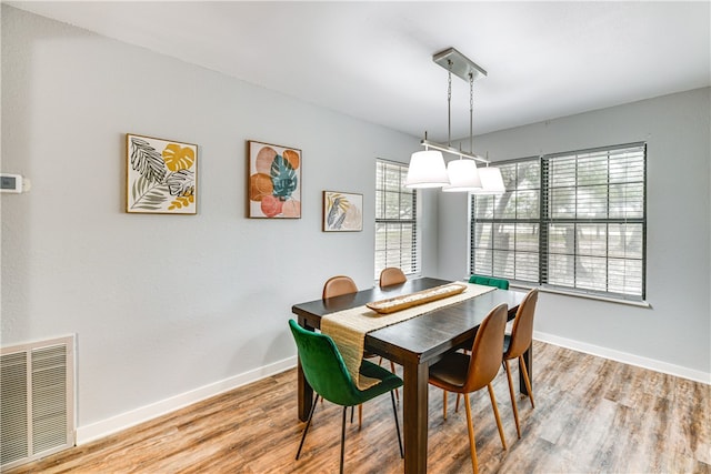 dining room with baseboards, light wood-type flooring, and visible vents