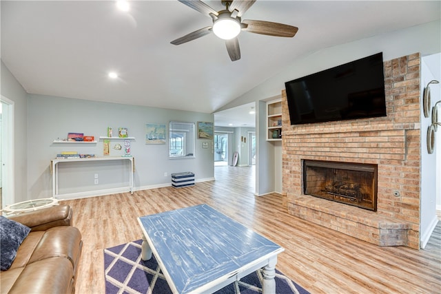 living room featuring a brick fireplace, a ceiling fan, baseboards, wood finished floors, and lofted ceiling