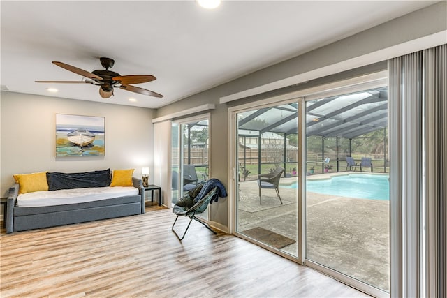 interior space featuring a sunroom, a ceiling fan, baseboards, recessed lighting, and wood finished floors