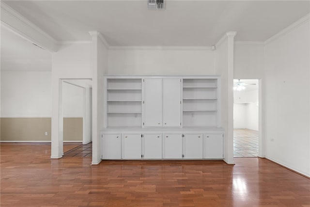 unfurnished living room with hardwood / wood-style flooring, ceiling fan, built in features, and ornamental molding