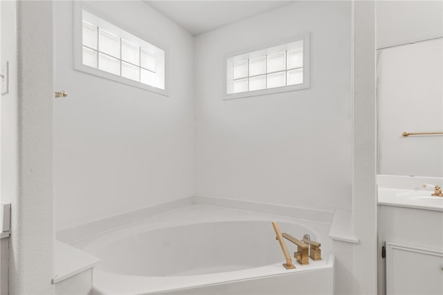 bathroom featuring vanity and a tub