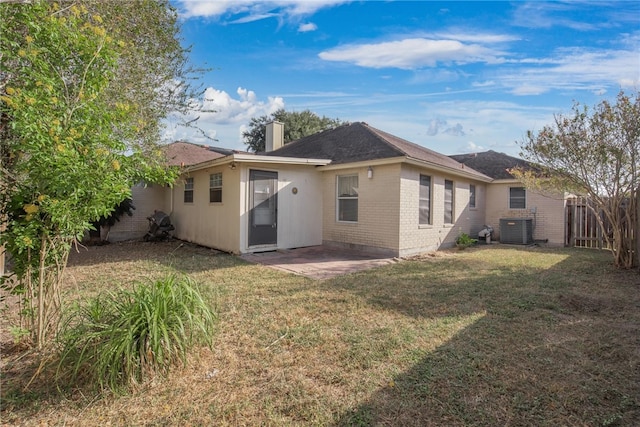 back of property featuring central AC and a yard