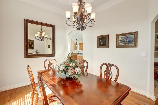 6613 Belvoir Ave, Corpus Christi, TX 78414 - dining room with arched walkways, a chandelier, and light wood-style flooring