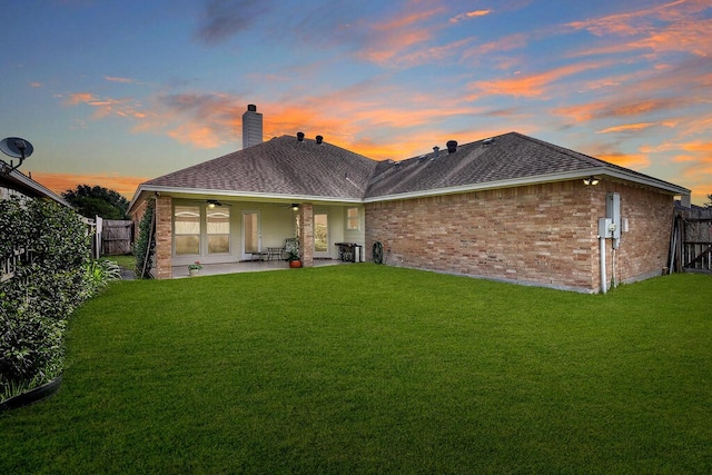 6613 Belvoir Ave, Corpus Christi, TX 78414 - back of house at dusk with brick siding, ceiling fan, a patio, a chimney, and roof with shingles