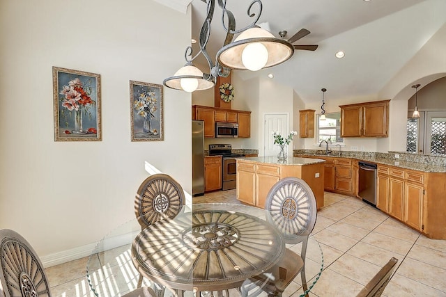 6613 Belvoir Ave, Corpus Christi, TX 78414 - kitchen with stainless steel appliances, arched walkways, a center island, ceiling fan, and light tile patterned floors