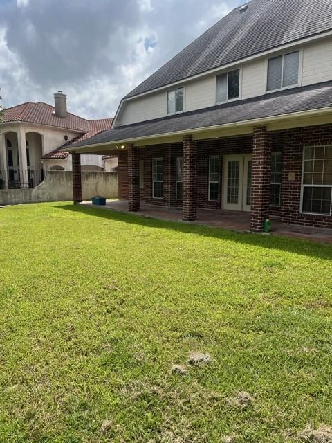 8038 Bar Le Doc Dr, Corpus Christi, TX 78414 - back of property featuring a patio, brick siding, and a chimney