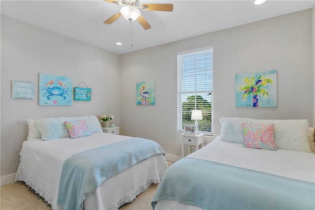 bedroom featuring multiple windows, light carpet, and ceiling fan