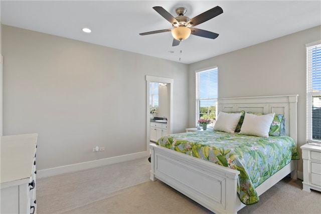 carpeted bedroom featuring multiple windows, ceiling fan, and ensuite bathroom