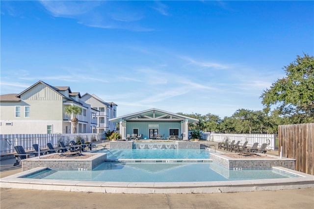 view of swimming pool with a hot tub and a patio area