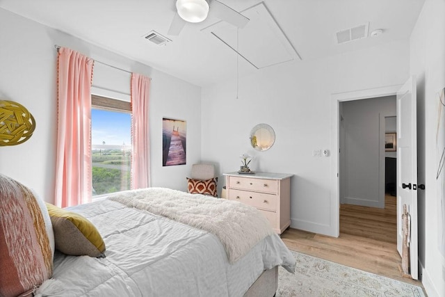 bedroom featuring attic access, baseboards, visible vents, and light wood-style floors