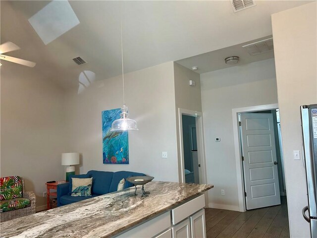 15110 Arashi Beach Dr, Corpus Christi, TX 78418 - kitchen featuring dark wood finished floors, white cabinetry, decorative light fixtures, light stone countertops, and ceiling fan