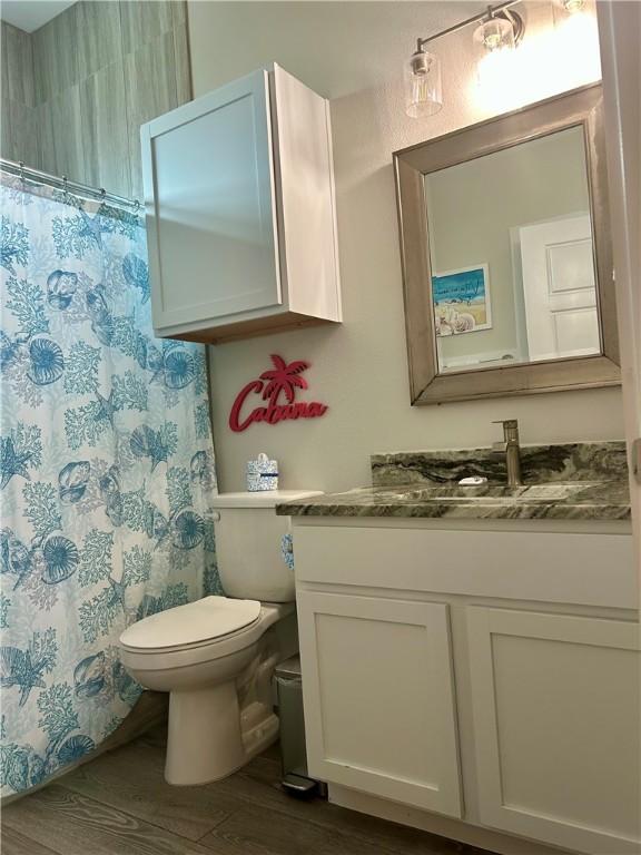 15110 Arashi Beach Dr, Corpus Christi, TX 78418 - full bath with vanity, wood finished floors, and a shower with shower curtain