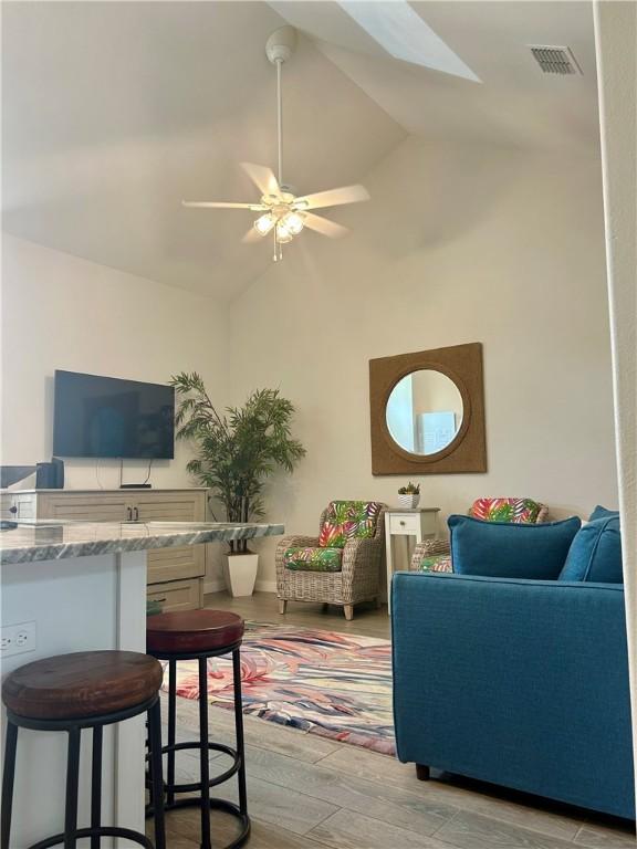15110 Arashi Beach Dr, Corpus Christi, TX 78418 - living area with a skylight, a ceiling fan, light wood finished floors, and high vaulted ceiling