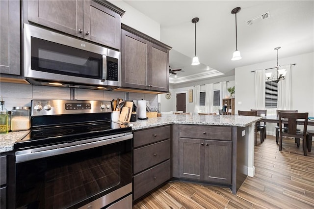 1570 Maryville Loop, Beeville, TX 78102 - kitchen with a peninsula, visible vents, dark brown cabinetry, a notable chandelier, and appliances with stainless steel finishes