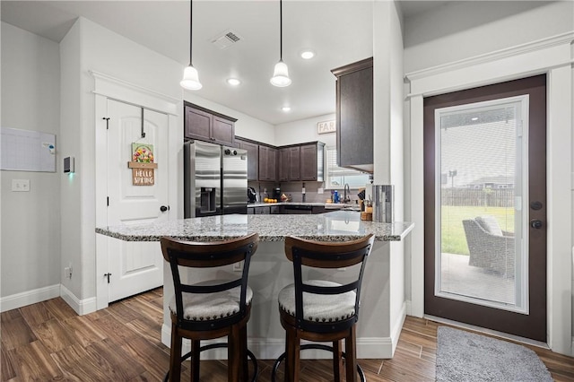 1570 Maryville Loop, Beeville, TX 78102 - kitchen featuring wood finished floors, a sink, light stone countertops, dark brown cabinetry, and stainless steel fridge