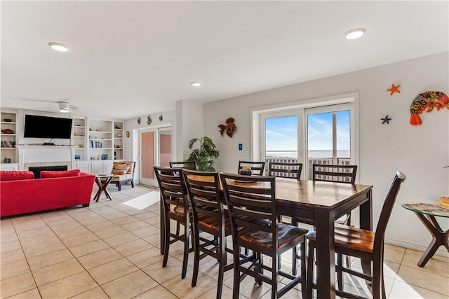 700 Island Retreat Rd Unit 138, Port Aransas, TX 78373 - dining area with light tile patterned flooring, a tiled fireplace, built in features, and recessed lighting