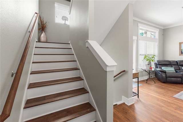 staircase with hardwood / wood-style flooring and crown molding