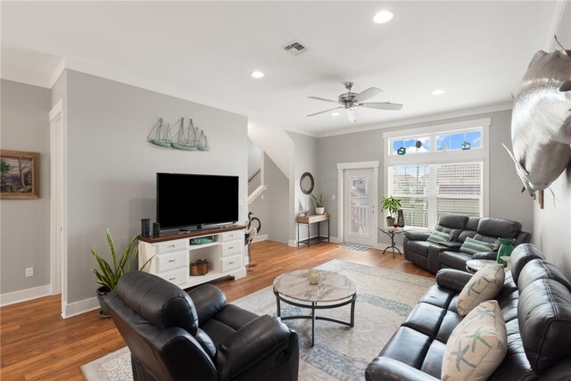 living room featuring ceiling fan, light wood-type flooring, and ornamental molding