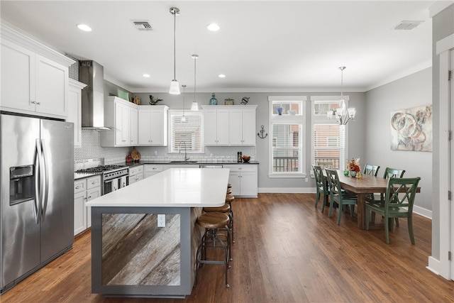 kitchen with white cabinetry, appliances with stainless steel finishes, decorative light fixtures, dark hardwood / wood-style floors, and sink