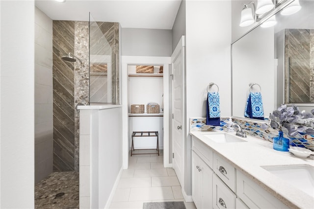 bathroom featuring a tile shower, vanity, and tile patterned floors