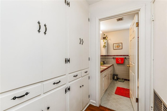 4009 Pope Dr, Corpus Christi, TX 78411 - bathroom with vanity, tile walls, and a wainscoted wall