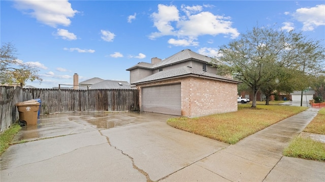 view of side of property with a garage and a lawn