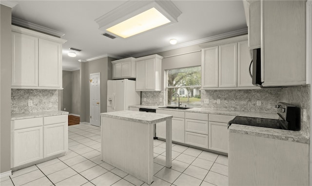 kitchen with white cabinetry, white refrigerator with ice dispenser, a center island, and sink