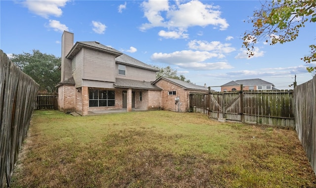 rear view of property featuring a lawn