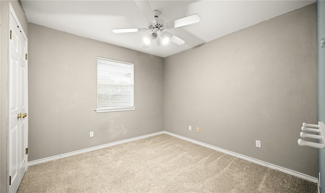 carpeted empty room featuring ceiling fan