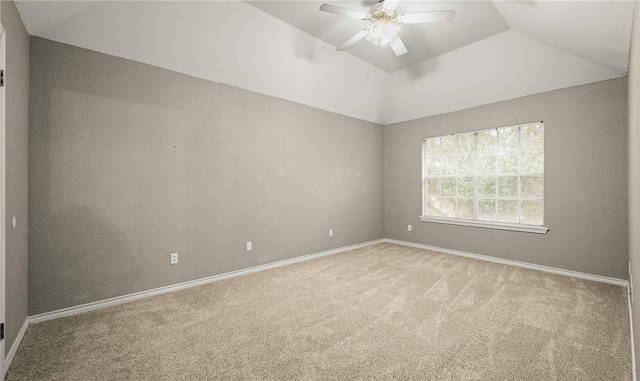 spare room featuring ceiling fan, light colored carpet, and vaulted ceiling