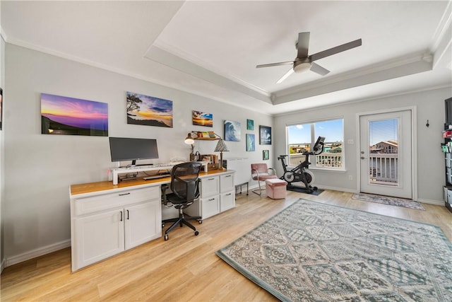 office space featuring light wood finished floors, baseboards, a ceiling fan, and a raised ceiling