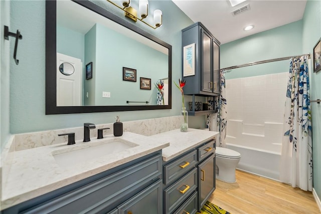 full bathroom featuring toilet, vanity, shower / bath combo, wood finished floors, and visible vents